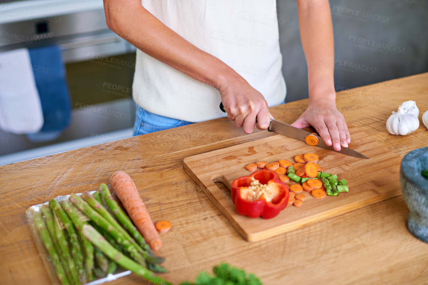 Buy stock photo Cropped shot of a woman chopping vegetables in the kitchen
