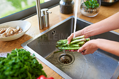 Buy stock photo Cropped shot of a woman washing vegetables in a kitchen sink