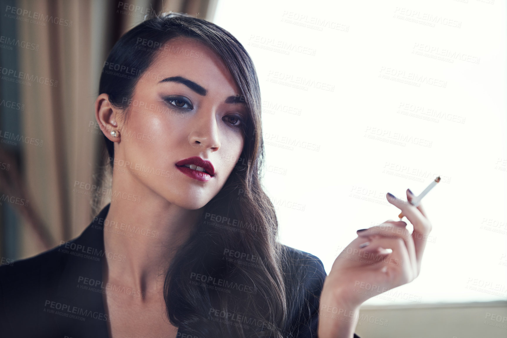 Buy stock photo Shot of an attractive and elegant young woman smoking
