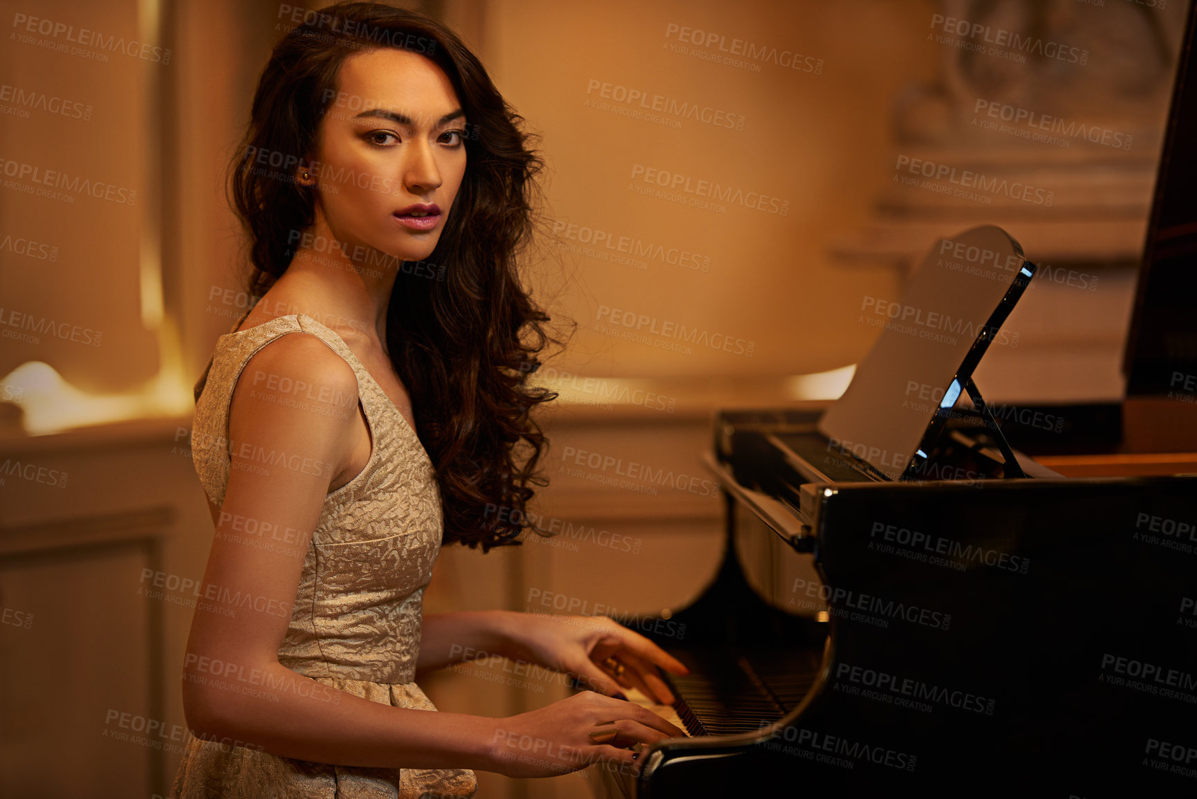 Buy stock photo Shot of a beautiful young woman playing the piano in an elegant room