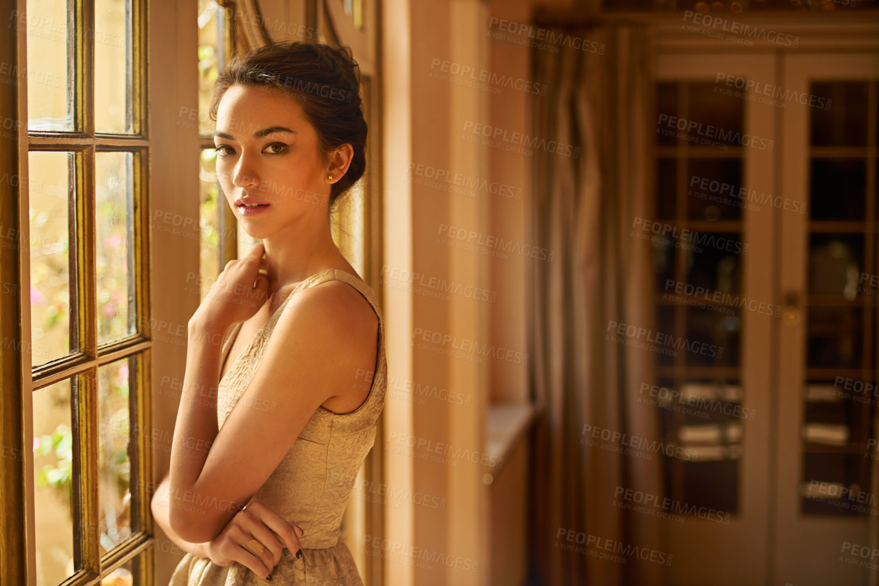 Buy stock photo Portrait of a beautiful young woman standing in an elegant room