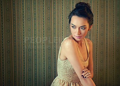 Buy stock photo Shot of a beautiful young woman dressed elegantly in a wallpapered room