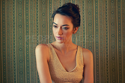 Buy stock photo Shot of a beautiful young woman dressed elegantly in a green wallpapered room