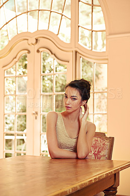 Buy stock photo Portrait of a beautiful young woman sitting at a table in her elegant home 