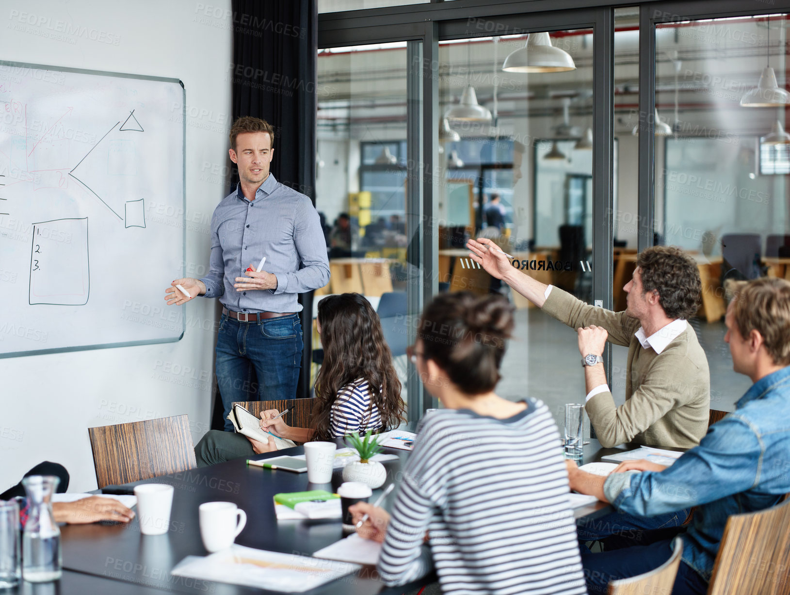 Buy stock photo Shot of a group of colleagues watching a presentation in a boardroom