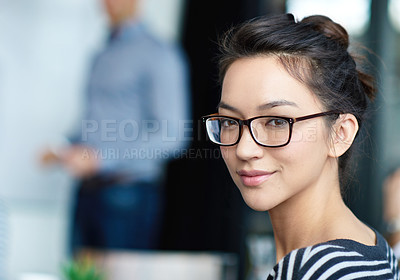 Buy stock photo Portrait of an attractive young woman sitting in an office with colleagues in the background