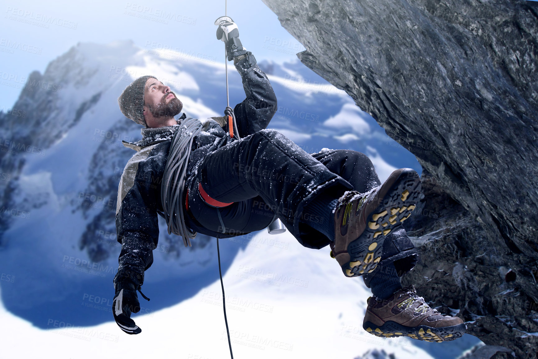 Buy stock photo Shot of a mountaineer hanging from a rope on a rockface