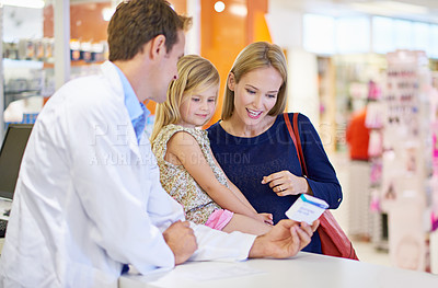 Buy stock photo A pharmacist giving medication to a mother and daughter