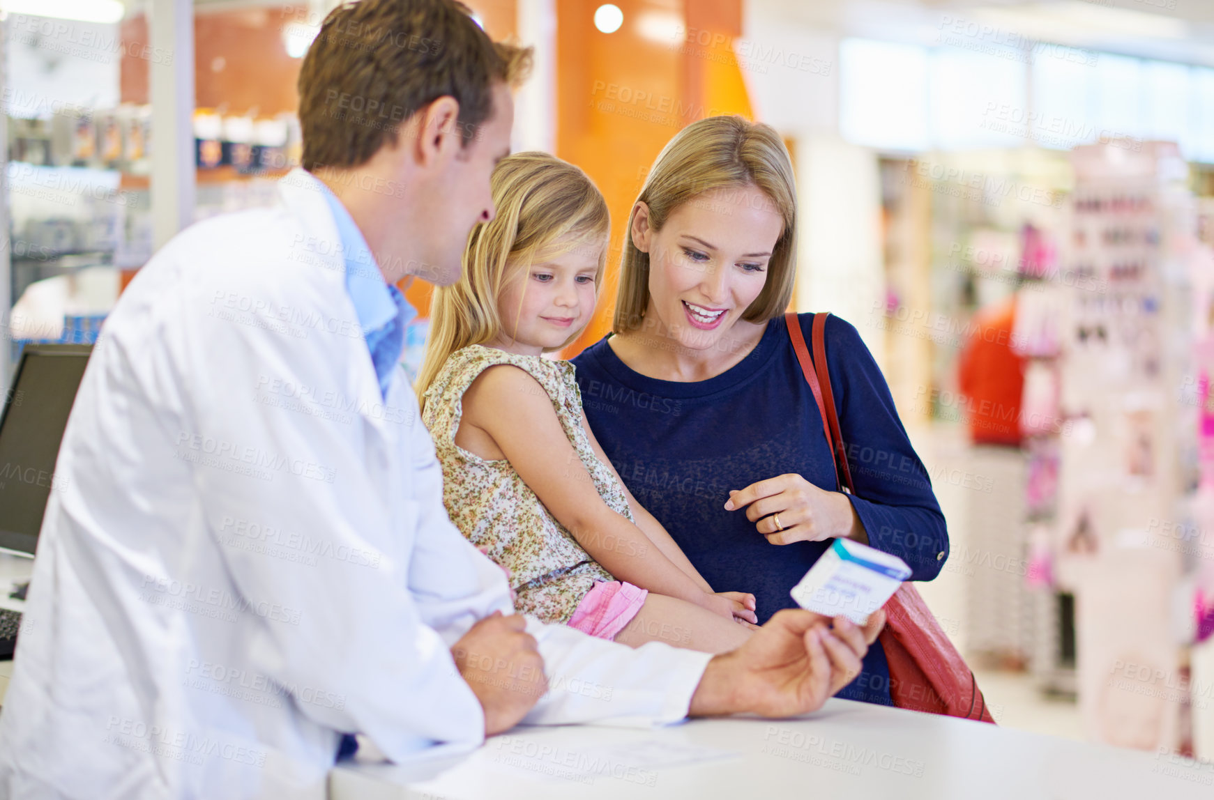 Buy stock photo A pharmacist giving medication to a mother and daughter