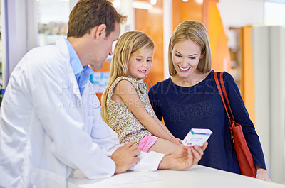 Buy stock photo Pharmacist, woman and child with pills in store for healthcare, wellness and smile with advice. Medicine, mother and daughter with box, supplements and discount for pharmaceutical product at shop