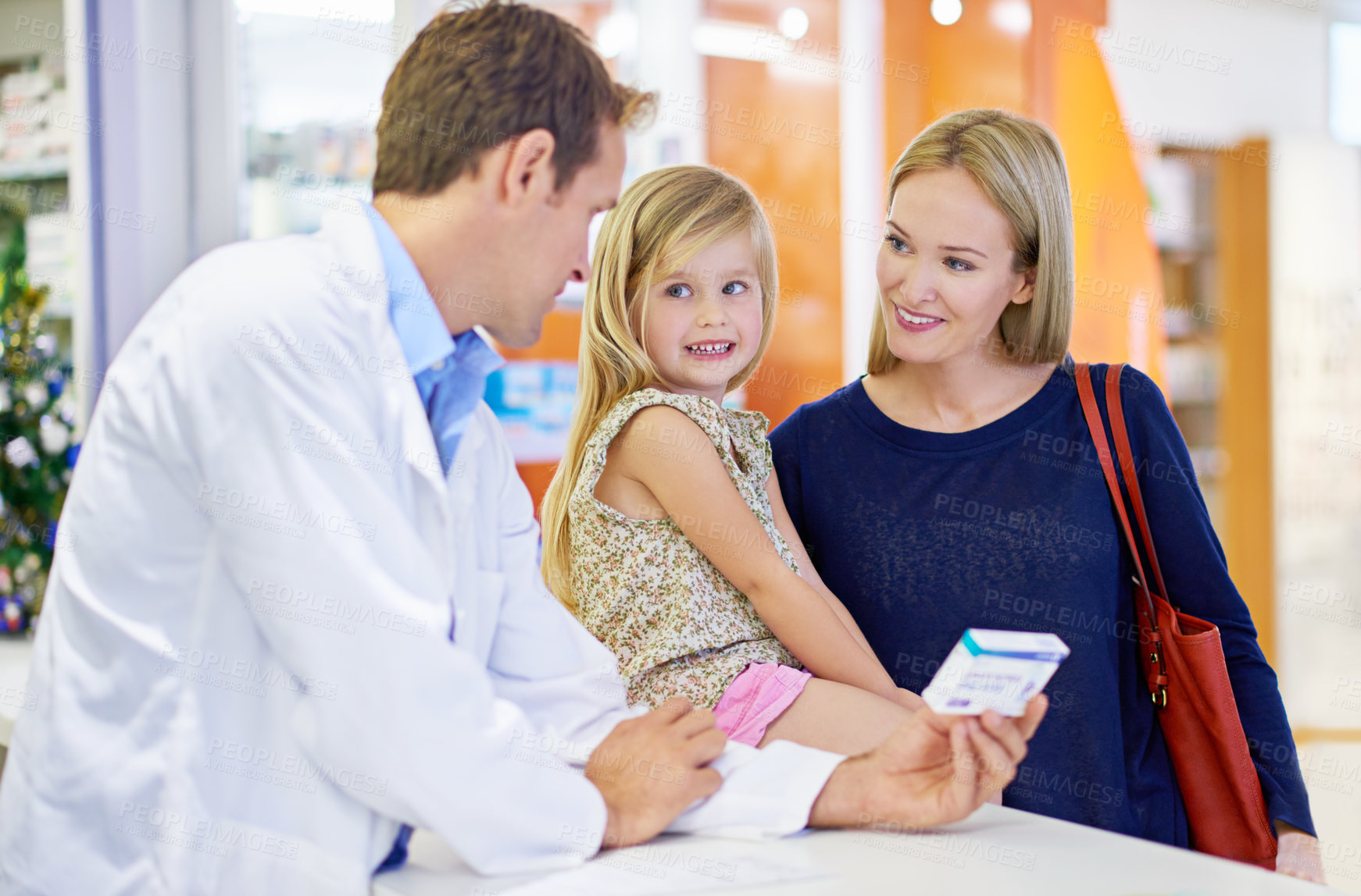 Buy stock photo A pharmacist giving medication to a mother and daughter