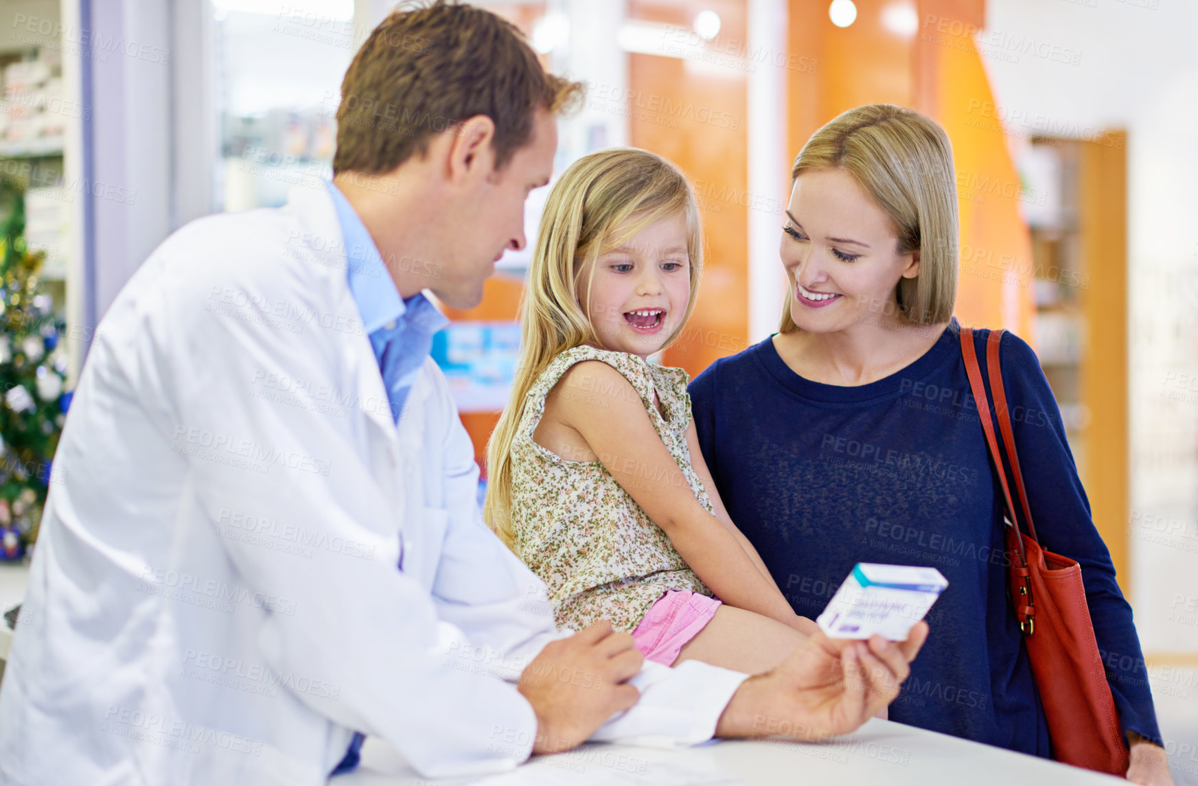 Buy stock photo A pharmacist giving medication to a mother and daughter