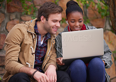 Buy stock photo Shot of a young couple sitting with a laptop on campus