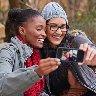 Buy stock photo Cropped shot of two female friends taking a selfie on campus