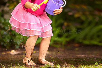 Buy stock photo Legs, girl and kid with toy bucket in muddy puddle for play, explore and child development in garden or backyard. Person, feet or toys in mud water for activity, playing and freedom outdoor in nature