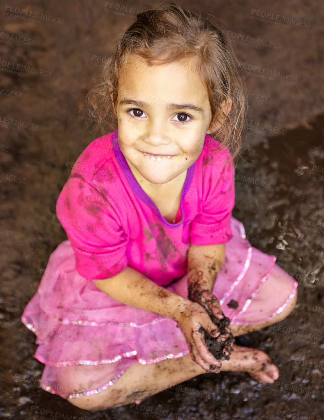 Buy stock photo Girl, kid and portrait with smile in mud for freedom, playing and muddy fun in sunshine weather or outdoor. Child, female and face of person with happiness for activity, enjoyment and relax in dirt