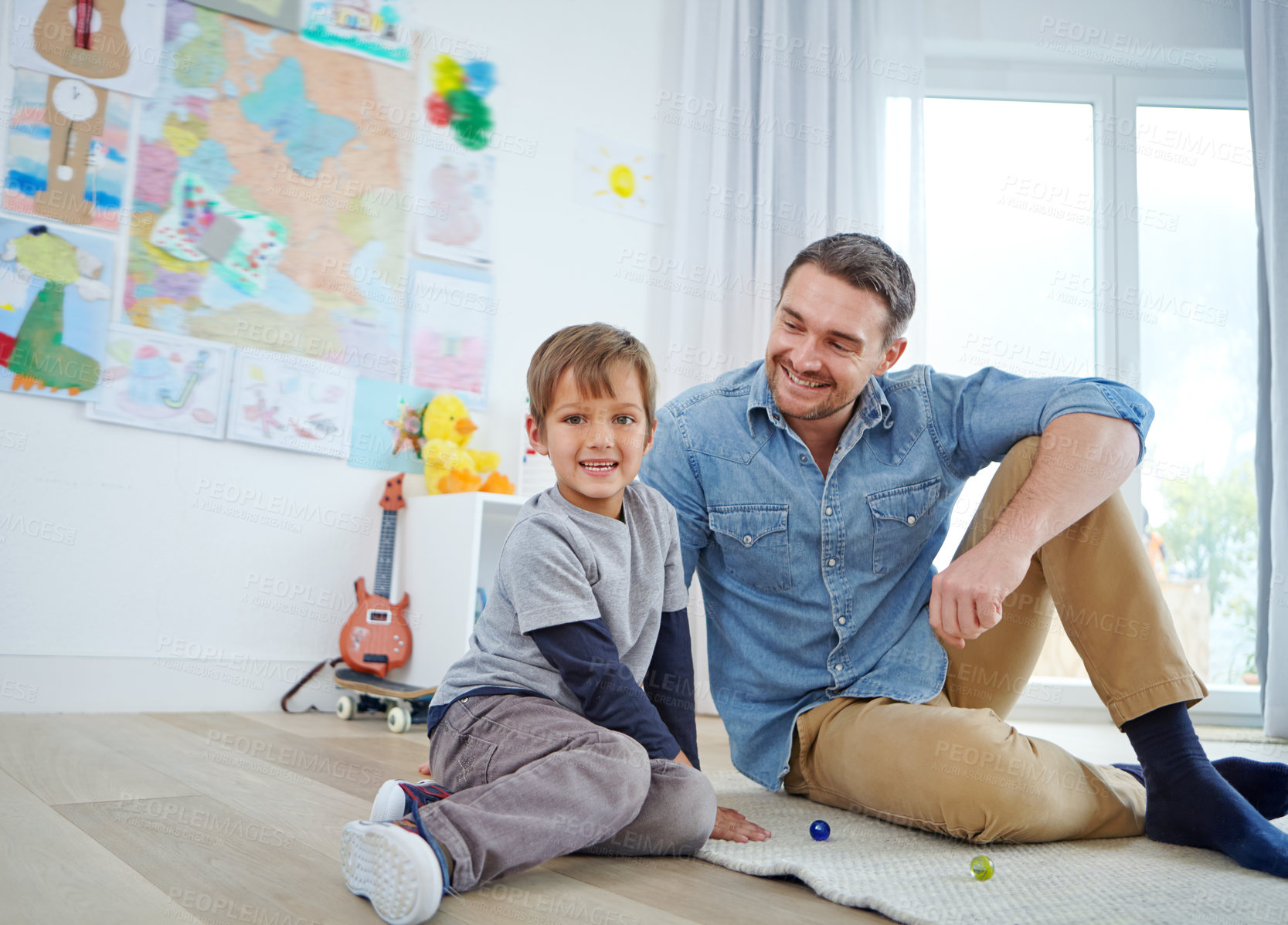 Buy stock photo Portrait of a happy father and son playing marbles together at home