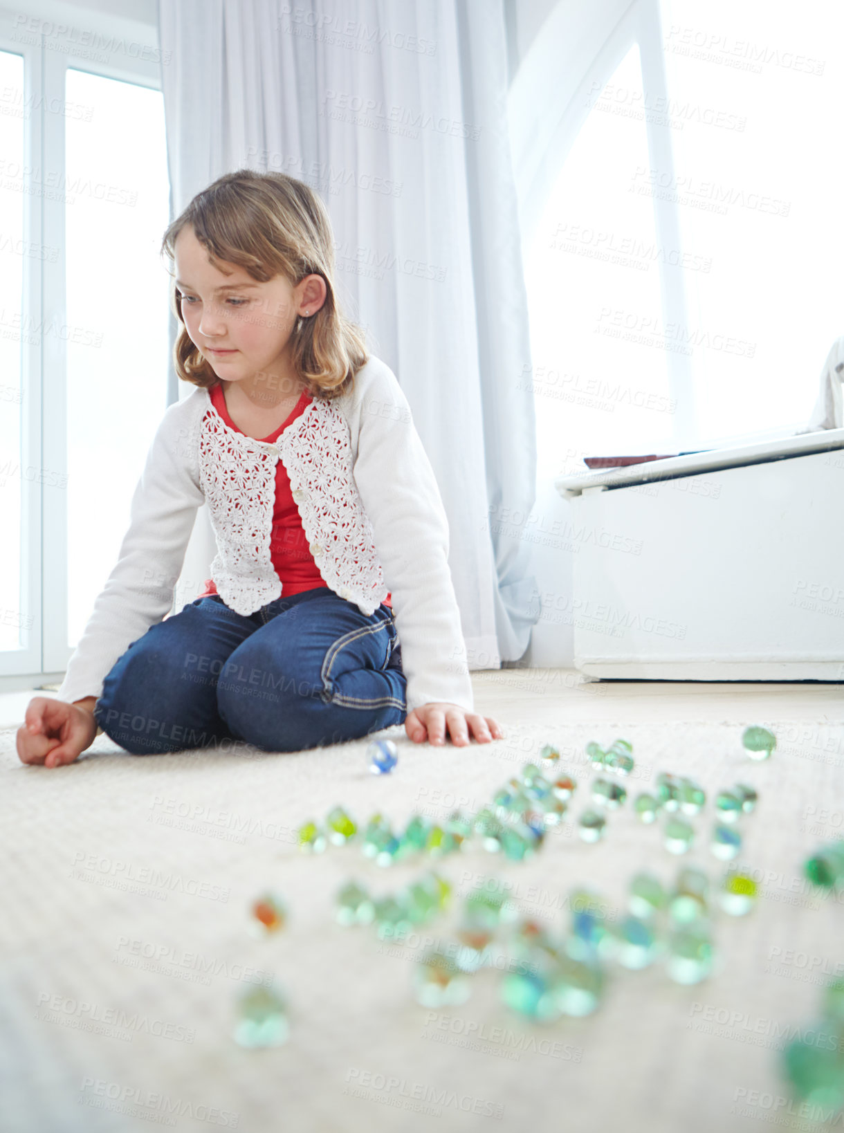 Buy stock photo Shot of an adorable little girl playing marbles at home