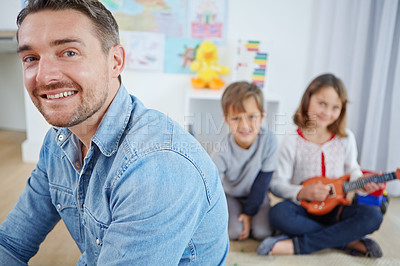 Buy stock photo Portrait of a handsome man spending the day with his son and daughter at home