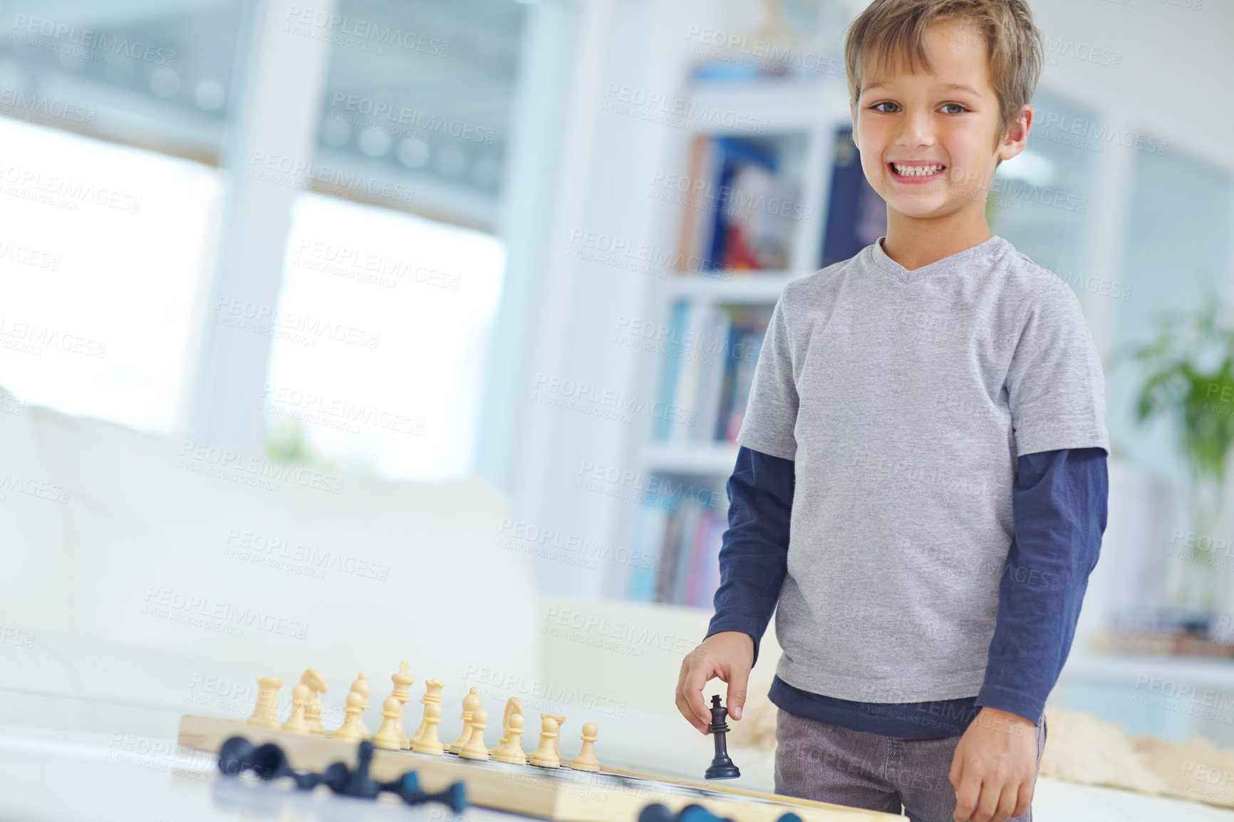 Buy stock photo Portrait of an adorable little boy playing a game of chess by himself at home