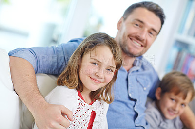 Buy stock photo Portrait of an adorable little girl relaxing on the sofa with her father and brother