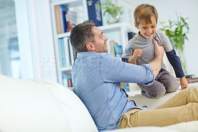 Buy stock photo Shot of a loving father and son playing together on the sofa at home