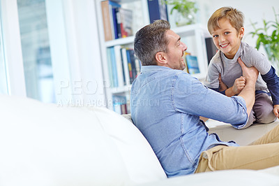 Buy stock photo Shot of a loving father and son playing together on the sofa at home