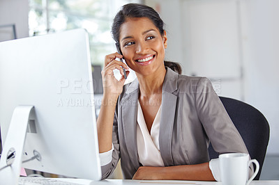 Buy stock photo Shot of a young businesswoman talking on the phone while sitting at her office desk