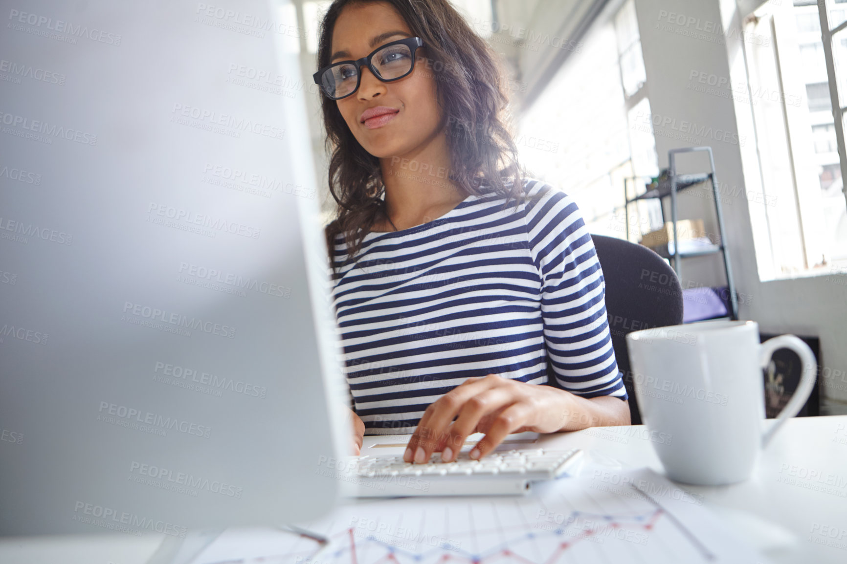 Buy stock photo Shot of a young female designer working on her computer