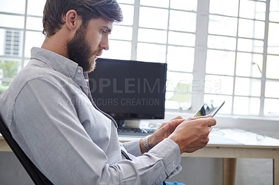 Buy stock photo Shot of a young designer using his digital tablet
