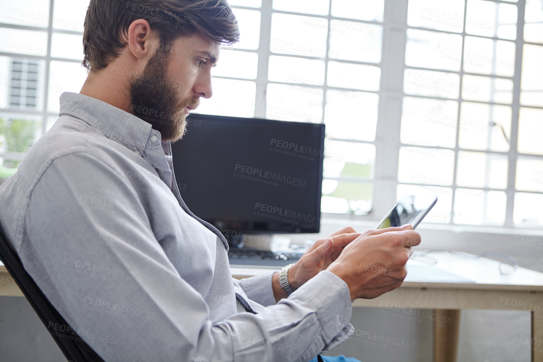 Buy stock photo Shot of a young designer using his digital tablet