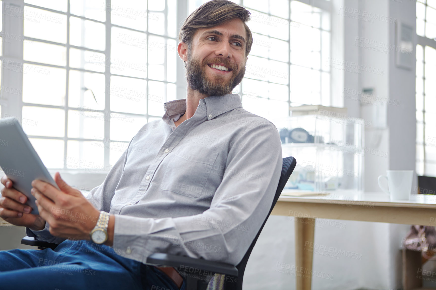 Buy stock photo Shot of a young designer using his digital tablet