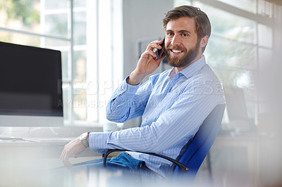 Buy stock photo Shot of a handsome designer talking on his phone at the office