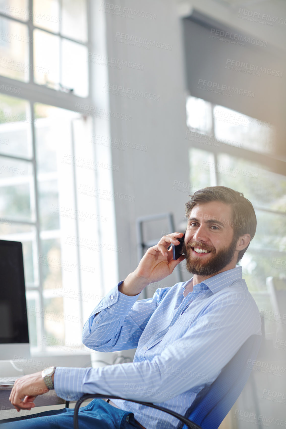 Buy stock photo Shot of a handsome designer talking on his phone at the office