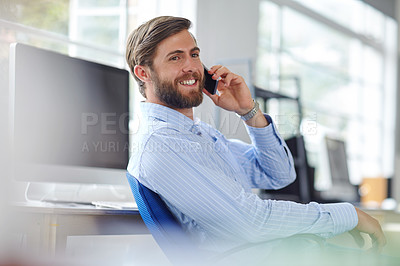 Buy stock photo Shot of a handsome designer talking on his phone at the office