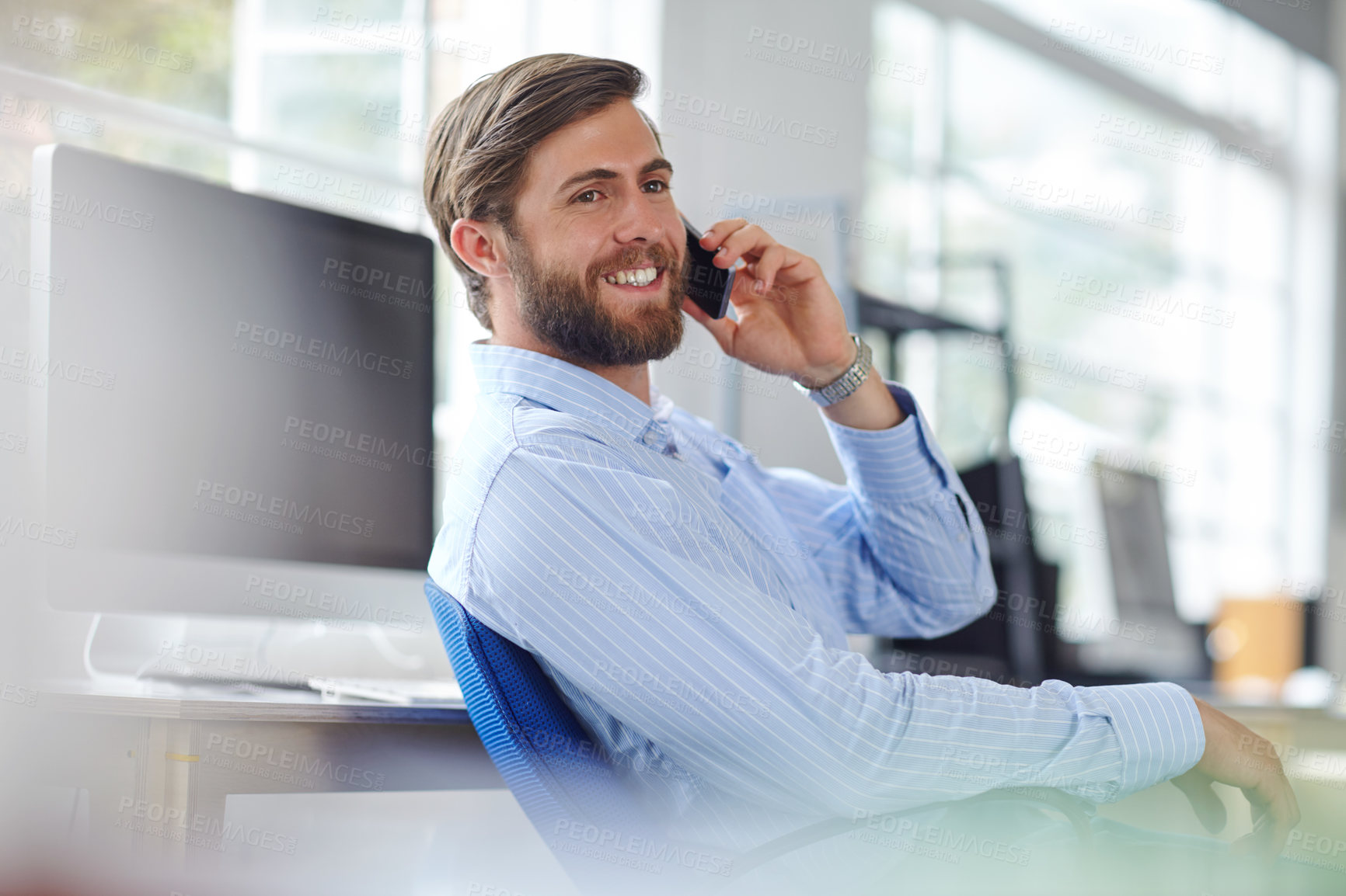 Buy stock photo Shot of a handsome designer talking on his phone at the office