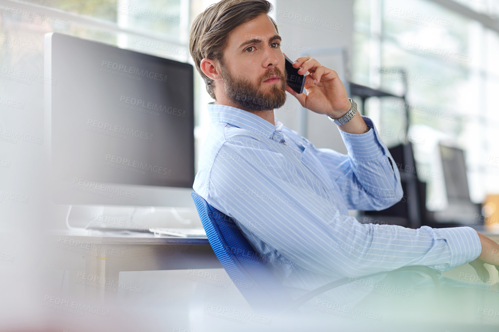 Buy stock photo Shot of a handsome designer talking on his phone at the office