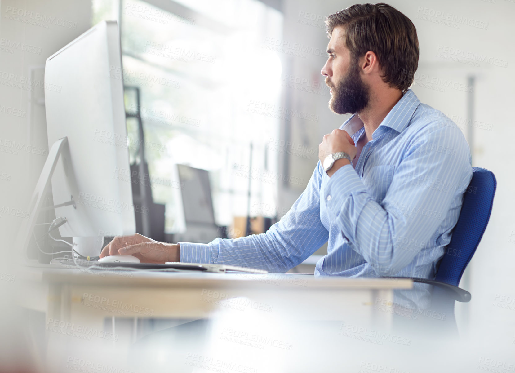 Buy stock photo Shot of a handsome designer sitting at his desk with his computer in front of him