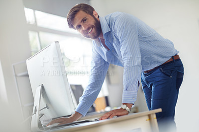 Buy stock photo Shot of a designer leaning towards his computer on his desk