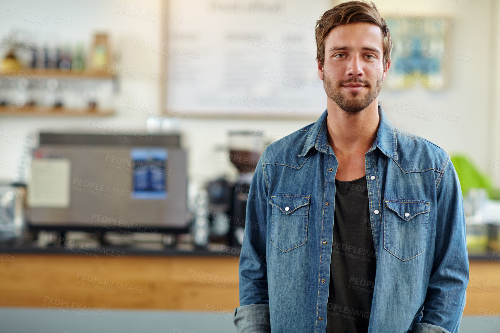 Buy stock photo Shot of a handsome young man standing in a coffee shop