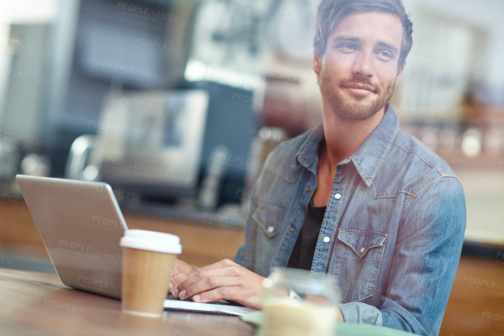 Buy stock photo Shot of a young man looking thoughtful while sitting with his laptop in a coffee shop