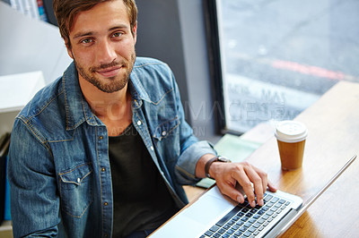 Buy stock photo Portrait of a handsome young man using his laptop in a coffee shop