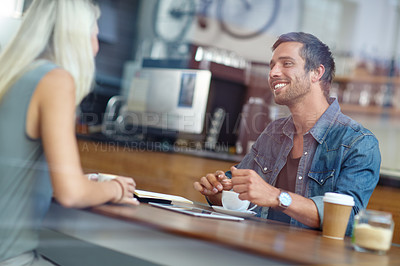 Buy stock photo Shot of a young couple enjoying a date at a coffee shop