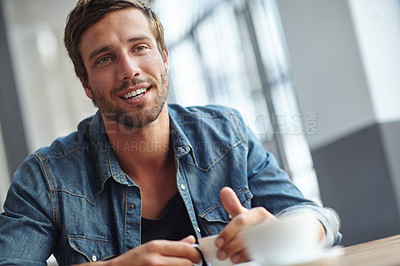 Buy stock photo Shot of a handsome young man having coffee at a cafe