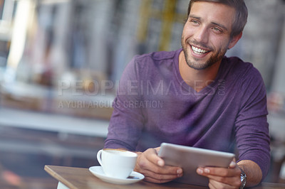 Buy stock photo Shot of a handsome young man looking thoughtful while sitting with his tablet in a coffee shop