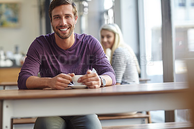 Buy stock photo Portrait of a handsome young man enjoying a cup of coffee at a cafe