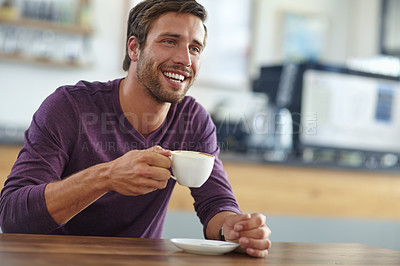Buy stock photo Shot of a handsome young man enjoying a cup of coffee at a cafe