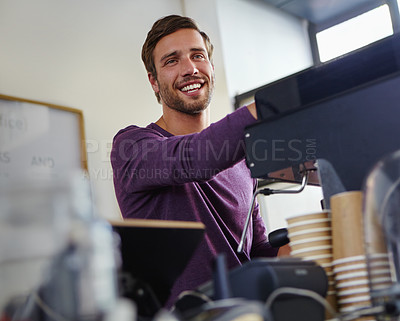 Buy stock photo Shot of a young male barista using an espresso machine in a coffee shop