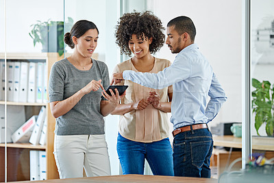 Buy stock photo Shot of office colleagues having a discussion over a digital tablet