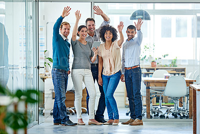 Buy stock photo Portrait of a diverse group of coworkers waving at the camera while standing in an office 